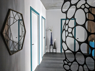 The first thing you see upon entering the apartment is a laser cut nature inspired room divider. It separates the entry area from the rest of the apartment while letting in as much natural light as possible.