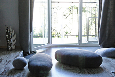 Pebble floor pillows with the view to the open balcony.