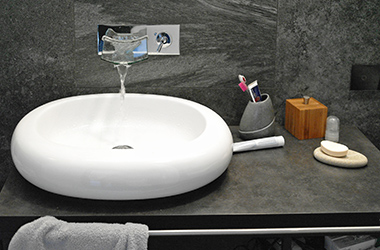 Gray natural stone tiles combine with the console almost seamlessly.